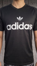 Vista frontal completa de hombre usando camiseta deportiva negra con cuello en V y logo clásico blanco en el pecho.