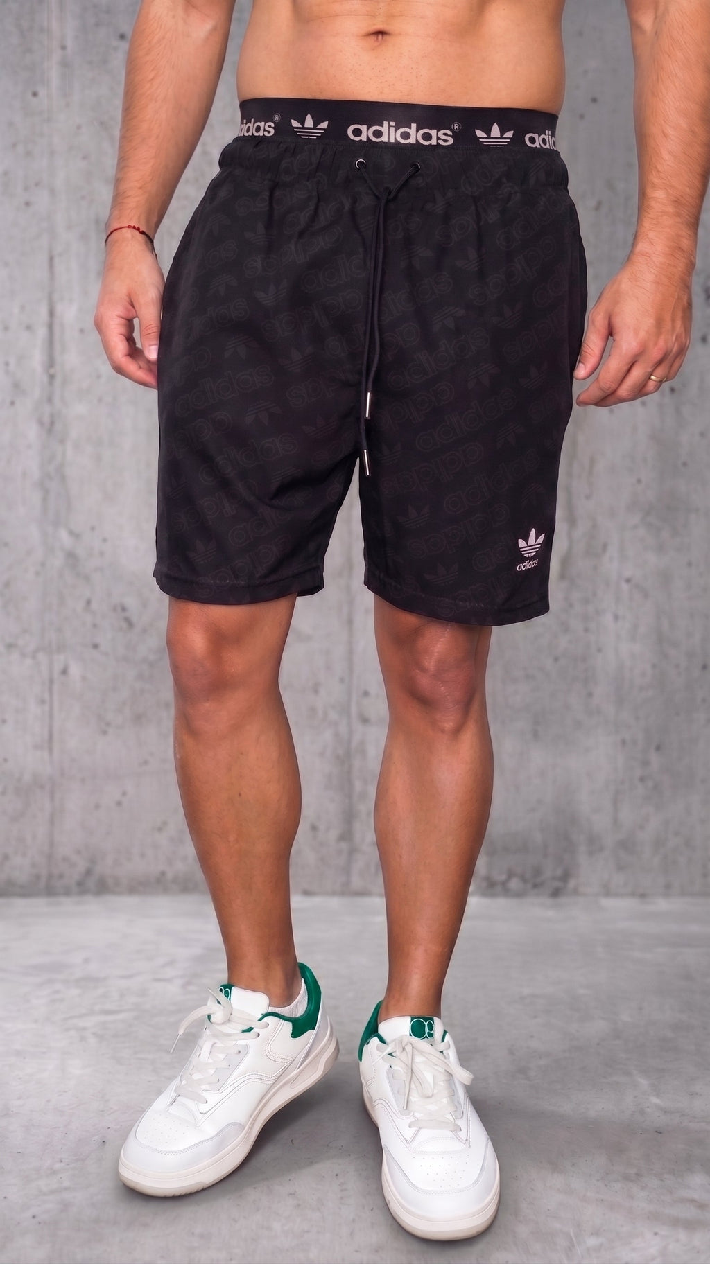 Pantaloneta deportiva negra para hombre con estampado repetido y pretina expuesta vista frontal
