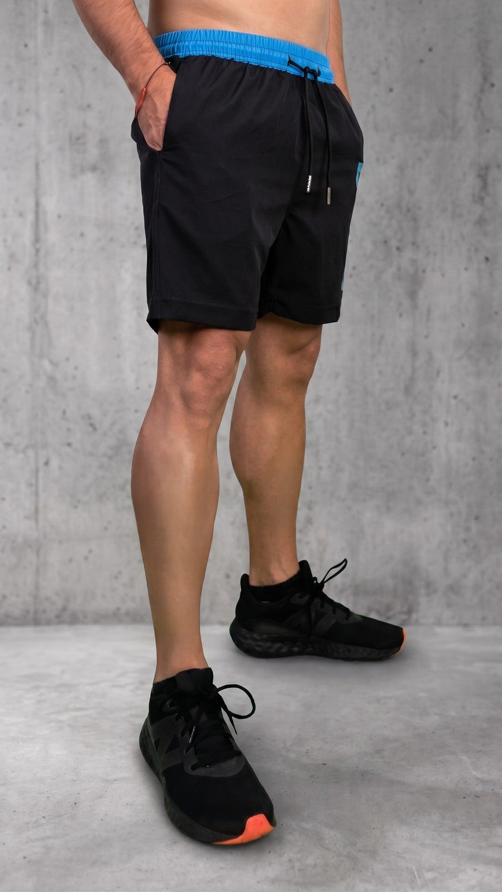Pantaloneta estilo streetwear negra con detalles azules vista de lado