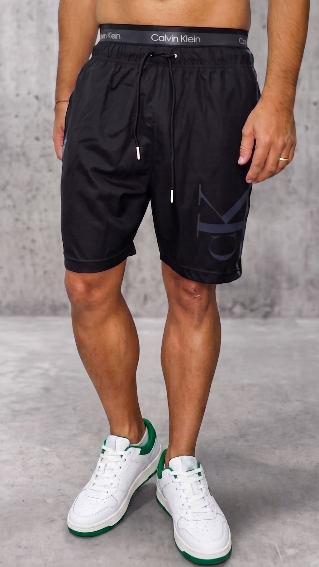 Pantaloneta estilo streetwear negra para hombre con pretina gris expuesta vista frontal