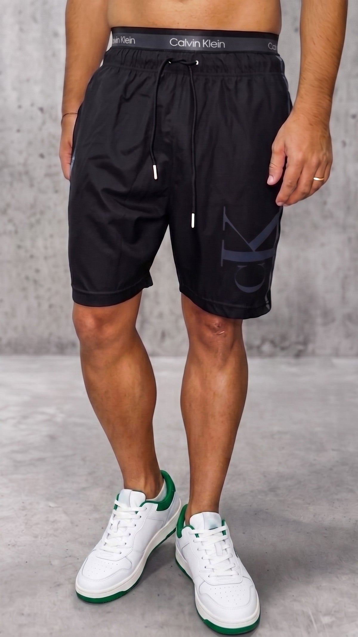 Pantaloneta estilo streetwear negra para hombre con pretina gris expuesta vista frontal