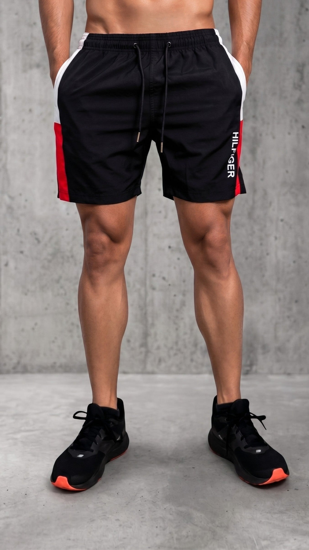 Pantaloneta negra para hombre con bloques laterales en blanco y rojo, modelo deportivo con cordón ajustable y logo Hilfiger en la pierna derecha